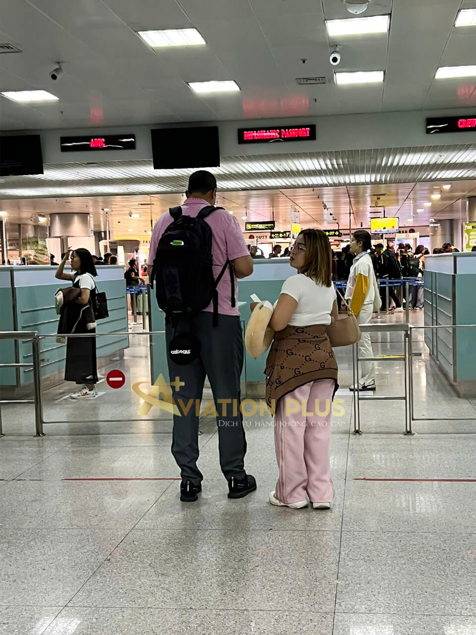 Cặp đôi chuẩn bị qua quầy kiểm tra tại sân bay